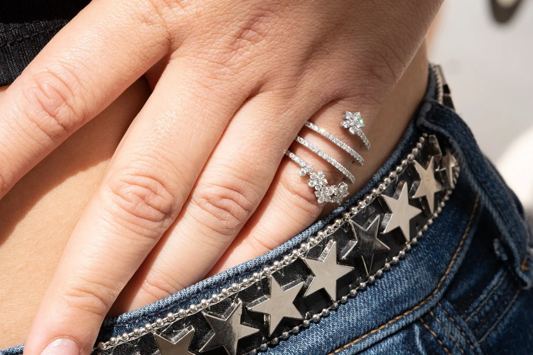 An open diamond pave swirl ring with diamond flowers